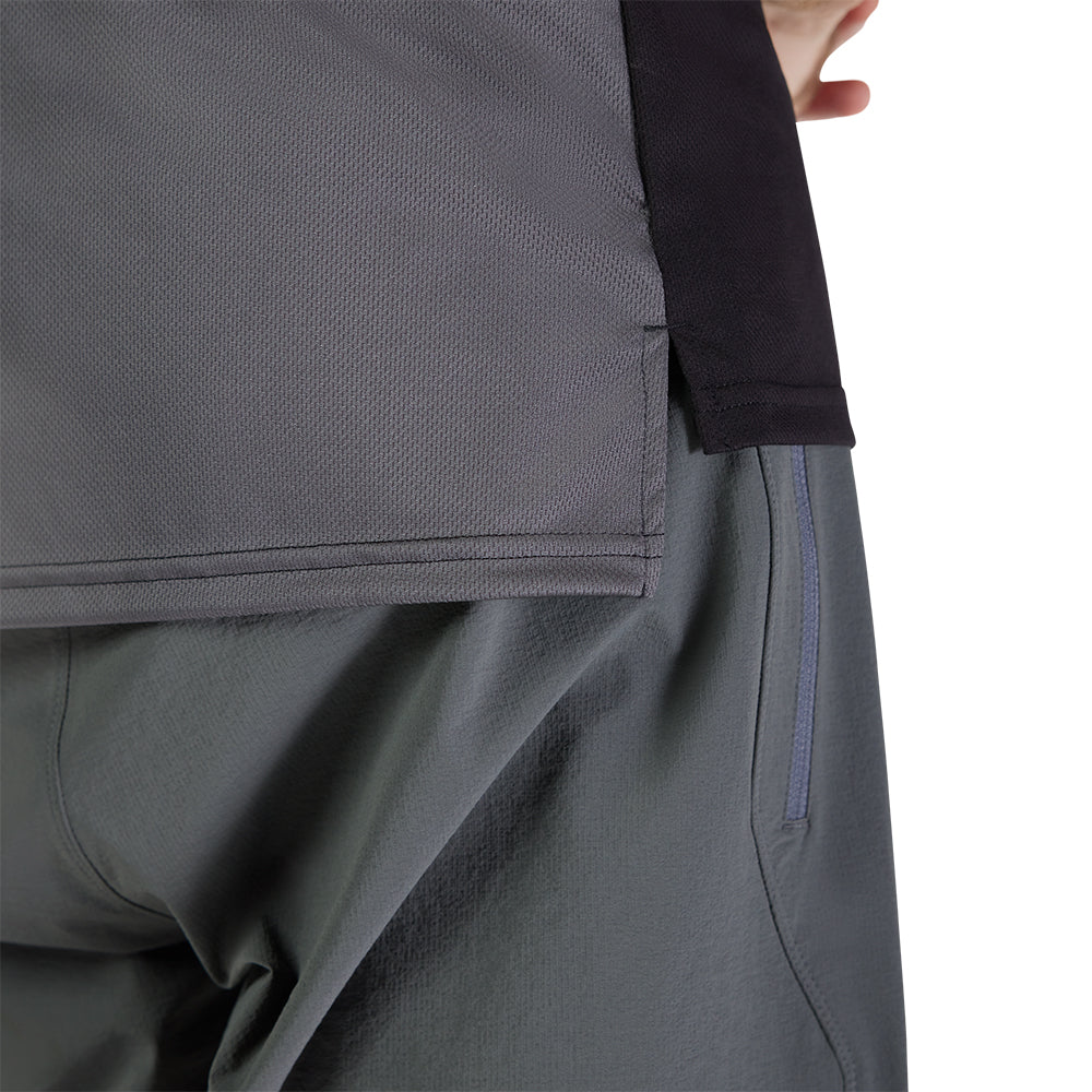 Close-up of gray pants with a person wearing them on a white background