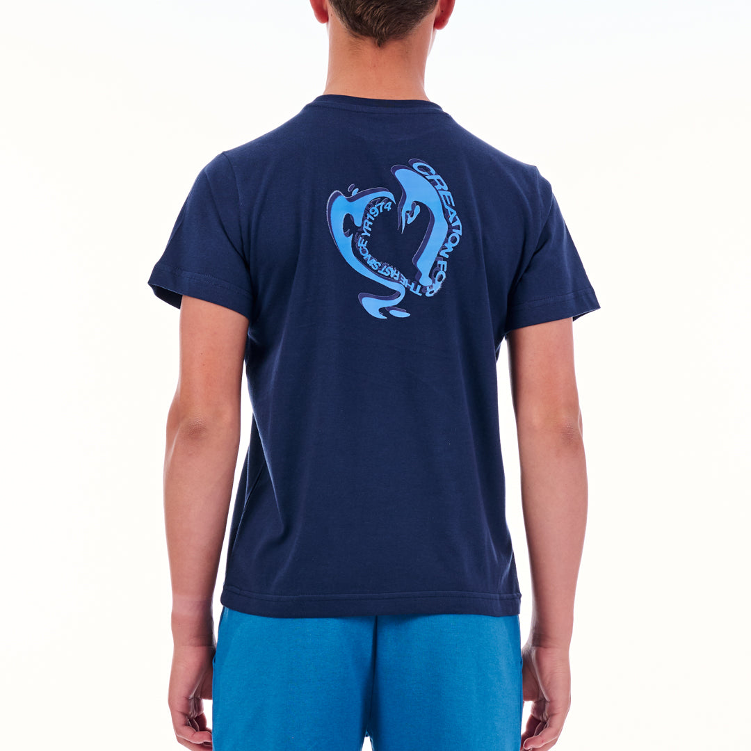 Person wearing a navy blue t-shirt with a dolphin graphic on the back, on a white background