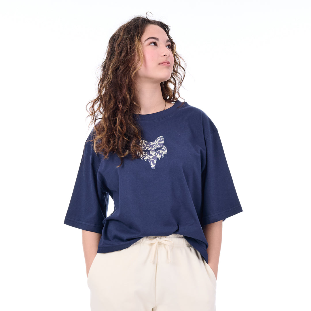 Woman wearing a navy blue t-shirt with a white graphic design on a white background