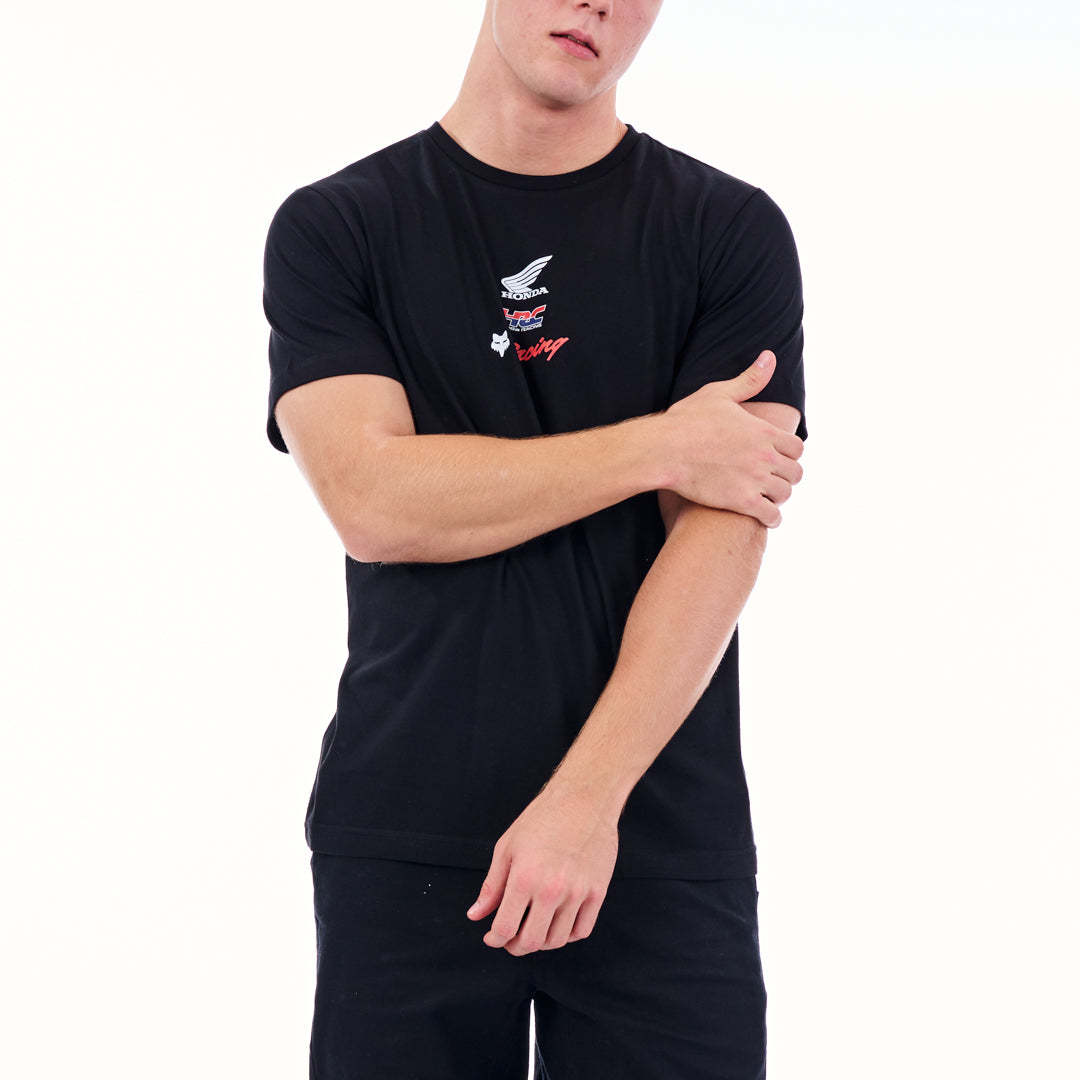 Person wearing a black t-shirt with logos on a white background