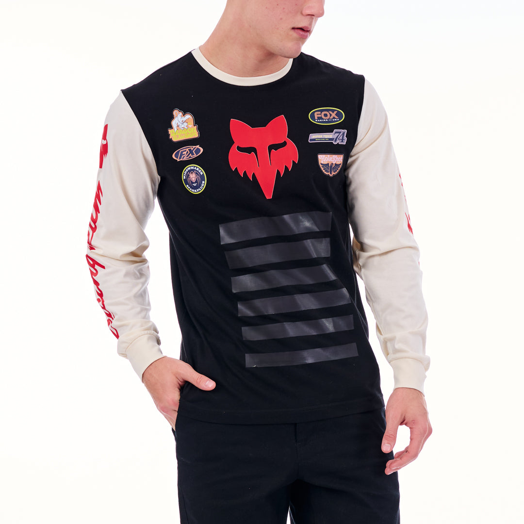 Person wearing a black and white long-sleeve shirt with various logos on a white background