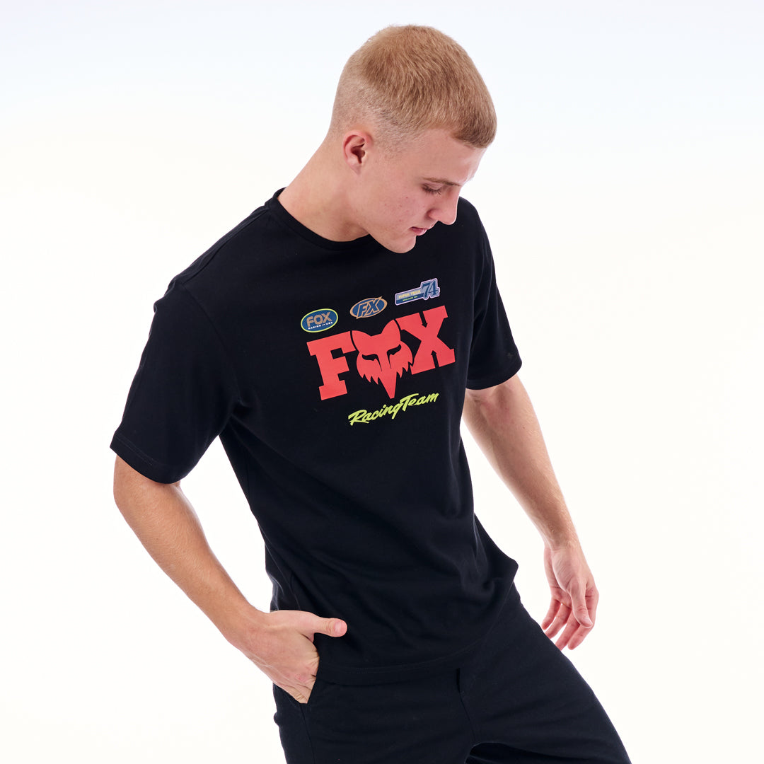 Person wearing a black t-shirt with red and yellow graphics on a white background