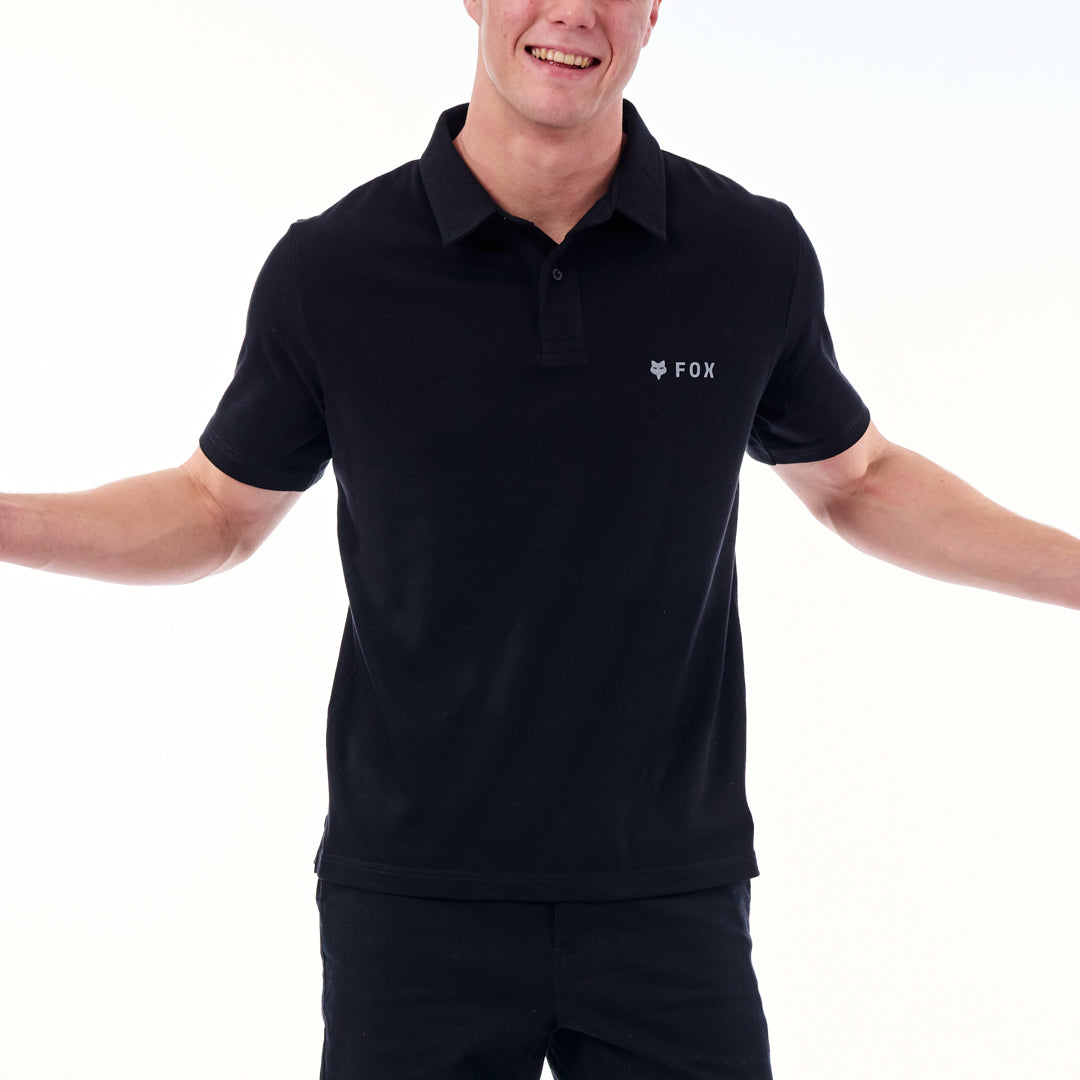 Person wearing a black polo shirt with a logo on a white background