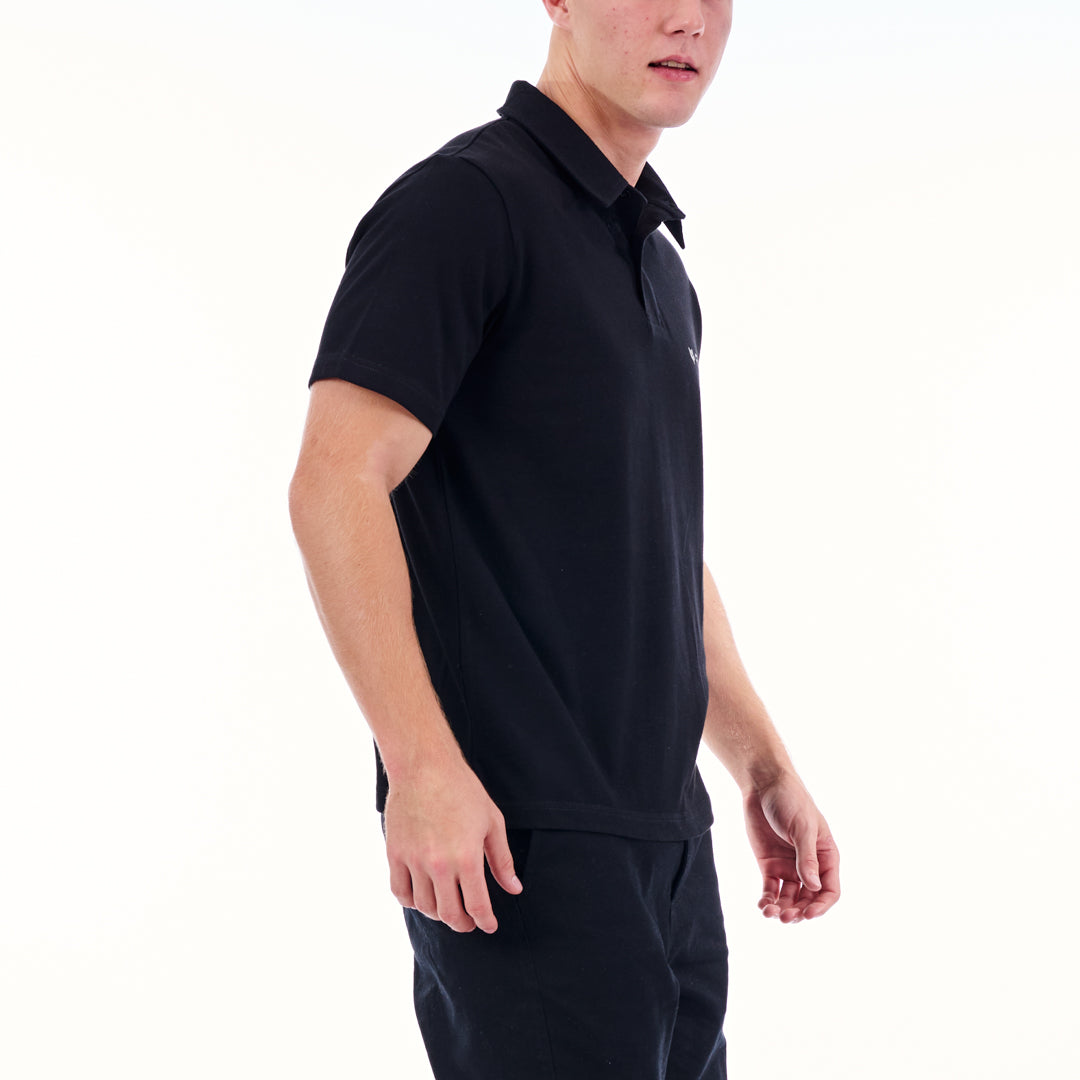 Person wearing a black polo shirt and pants on a white background