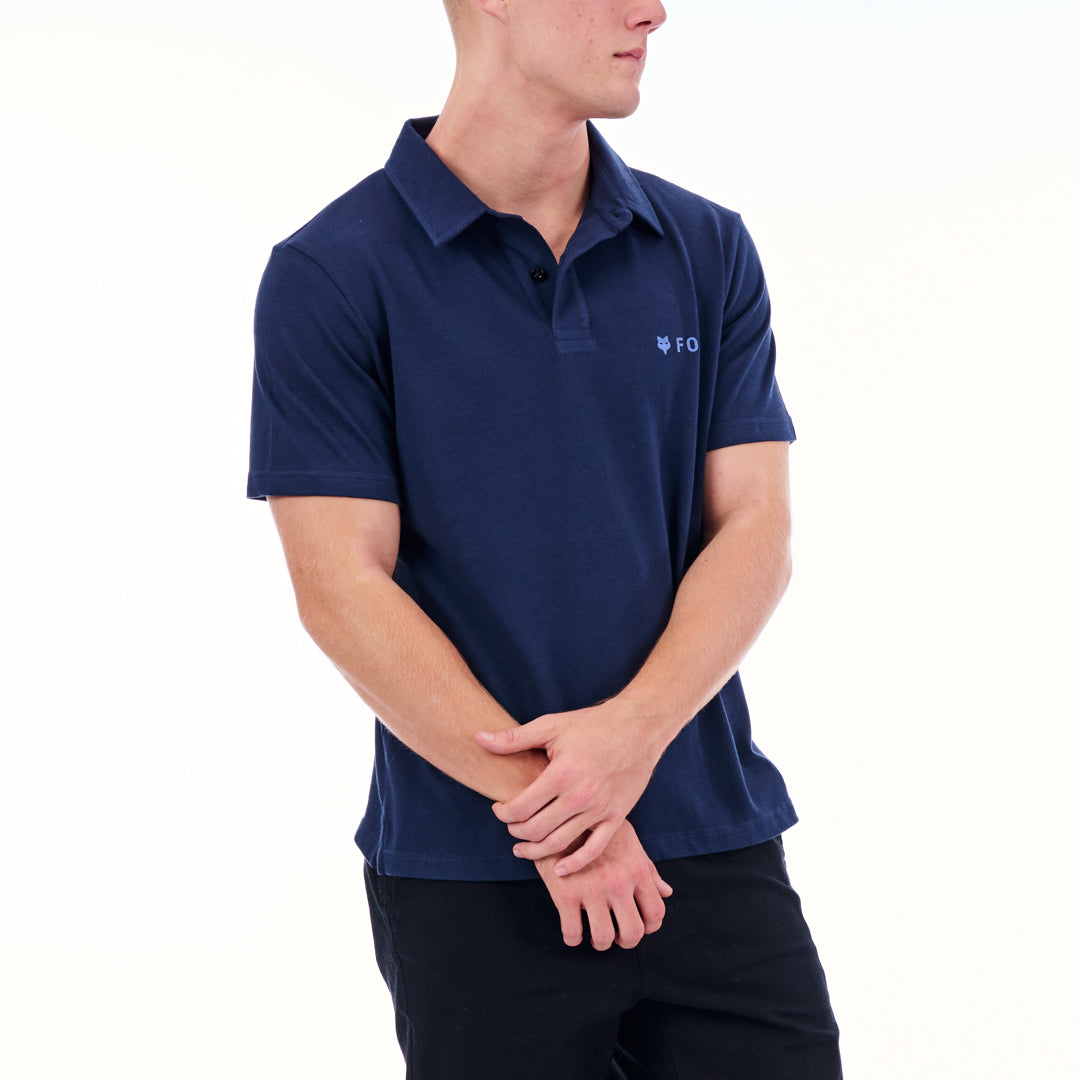 Person wearing a navy blue polo shirt with a logo on a white background
