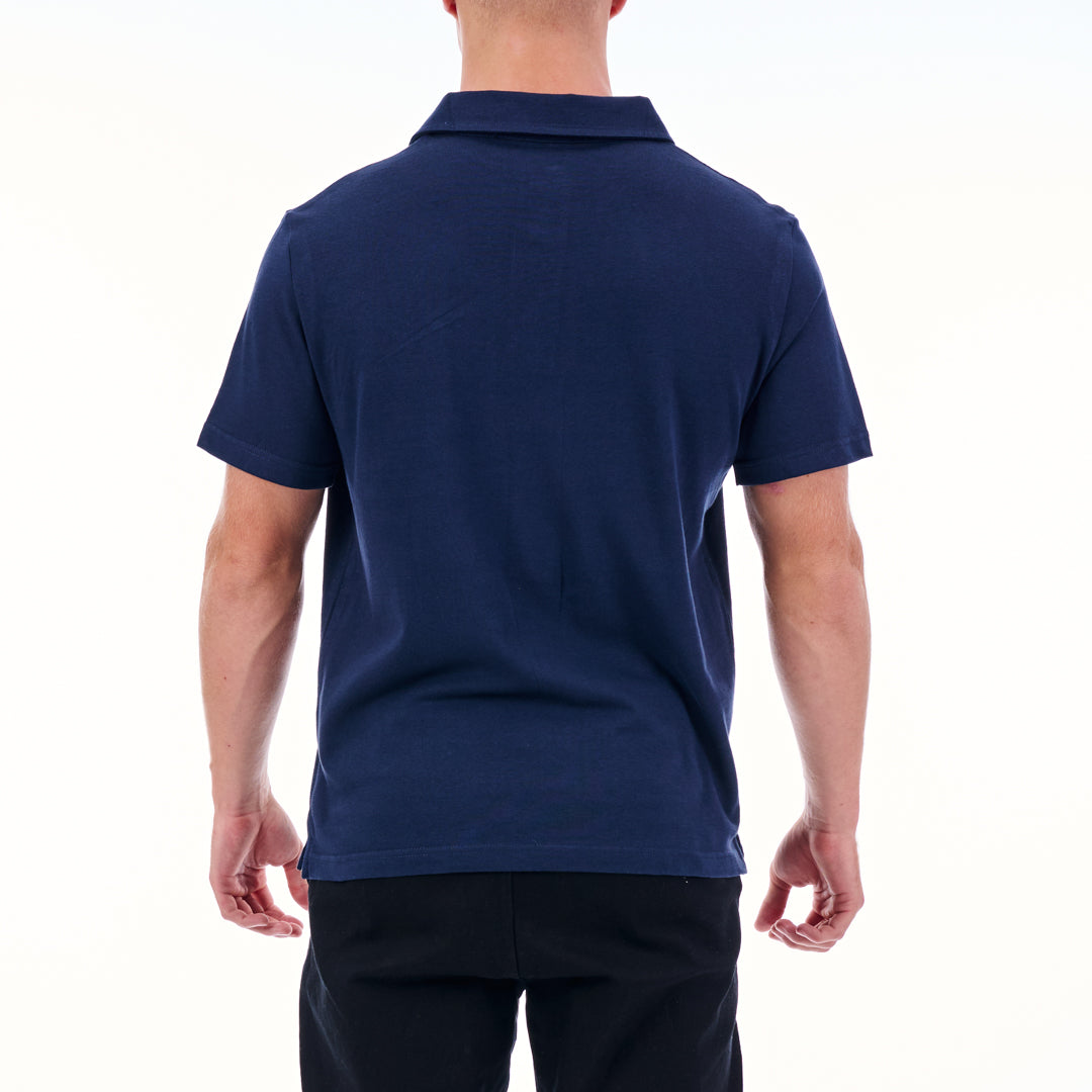 Person wearing a navy blue polo shirt on a white background