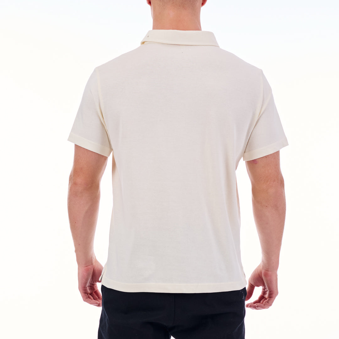 Person wearing a white polo shirt on a white background