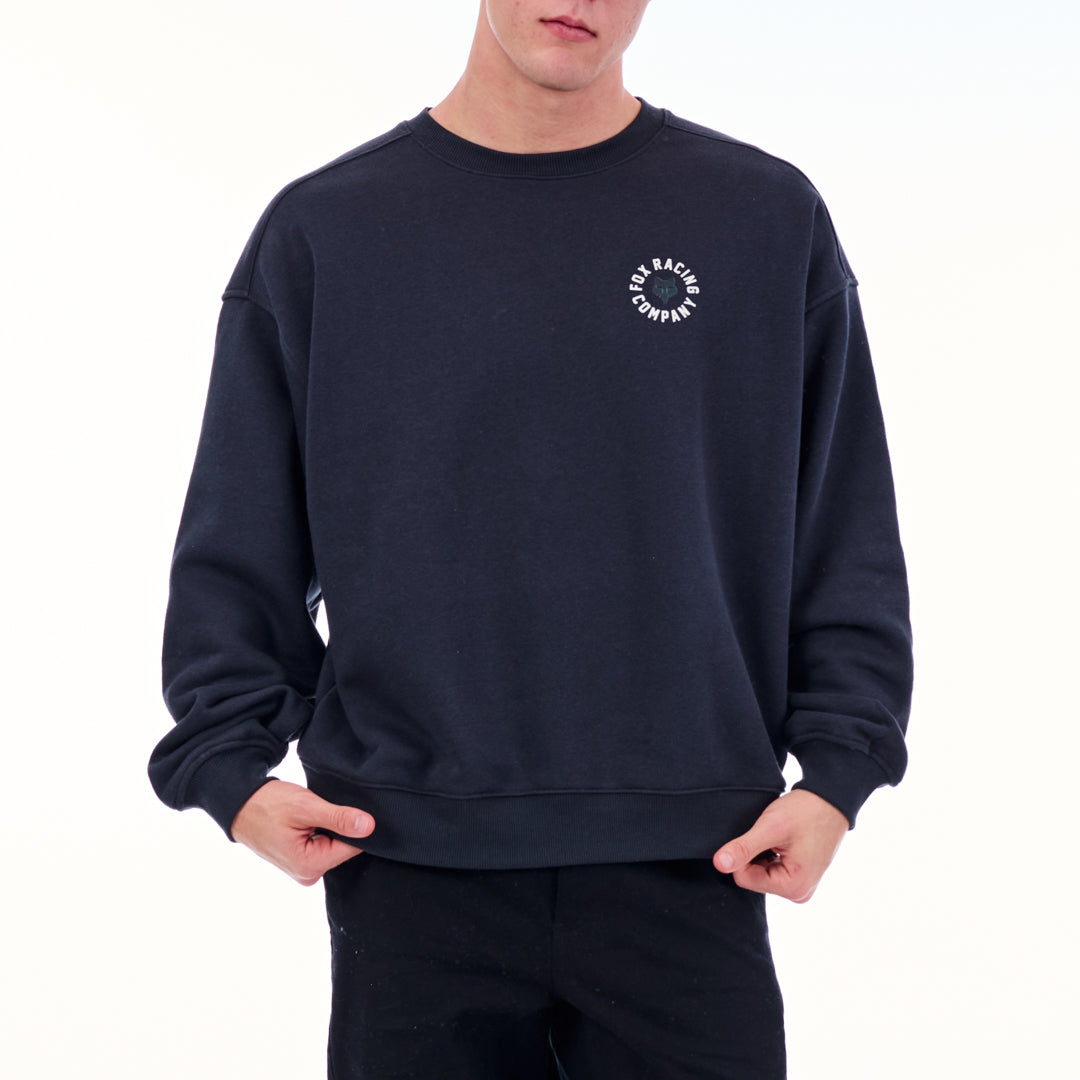 Person wearing a navy blue sweatshirt with a logo on a white background
