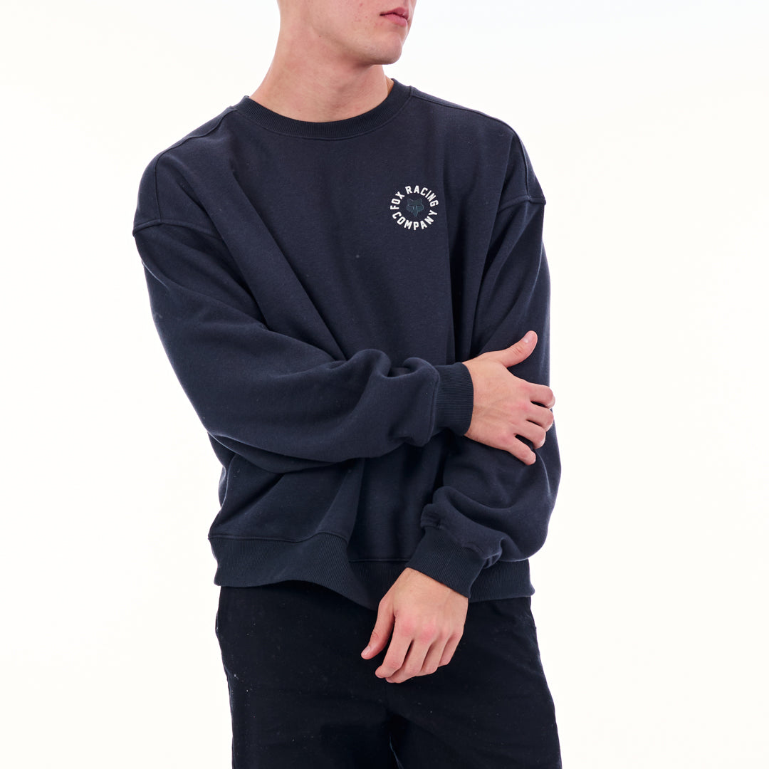Person wearing a navy blue sweatshirt with a logo on a white background