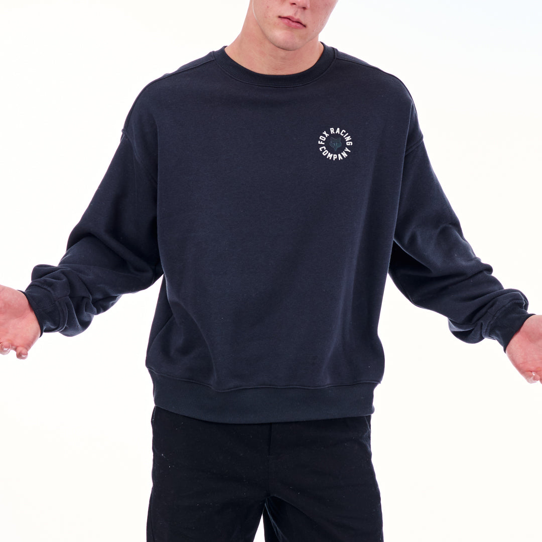 Person wearing a navy blue sweatshirt with a logo on a white background