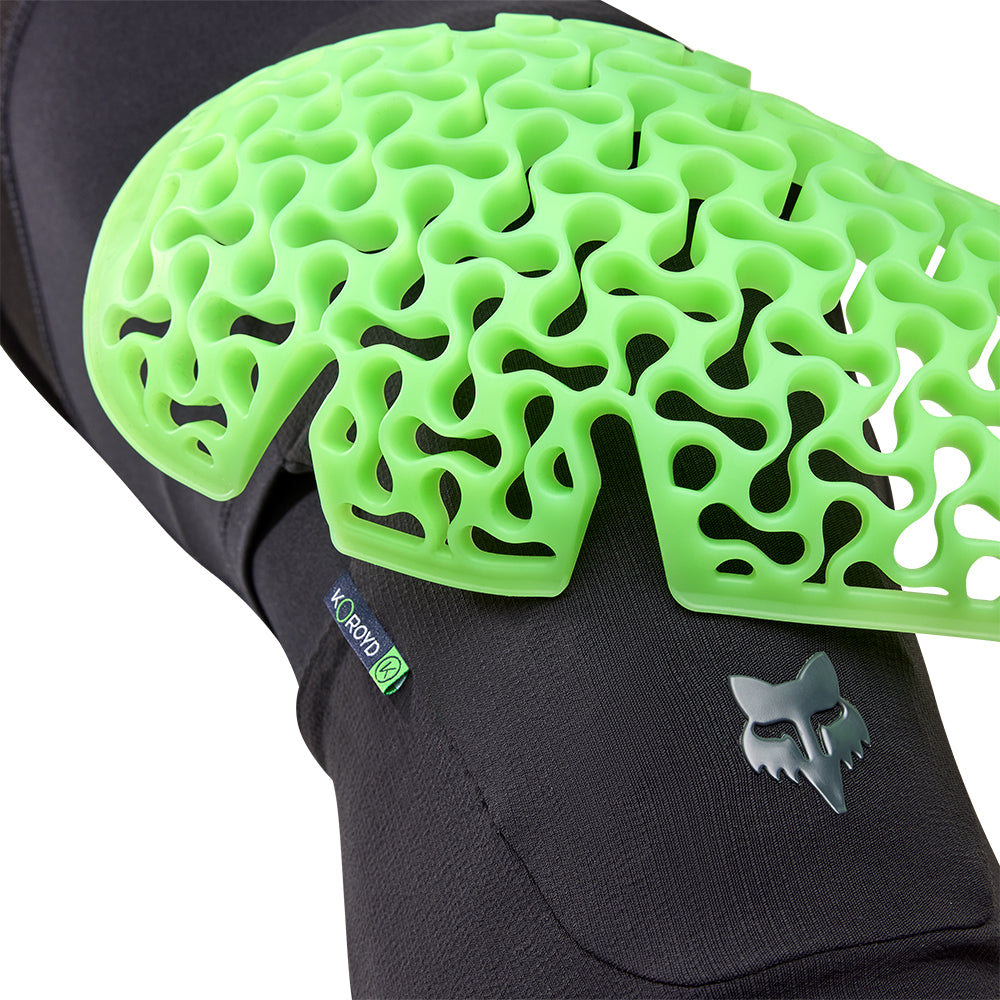 Black knee pad with green textured padding on a white background