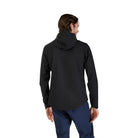 Person wearing a black jacket and blue pants on a white background