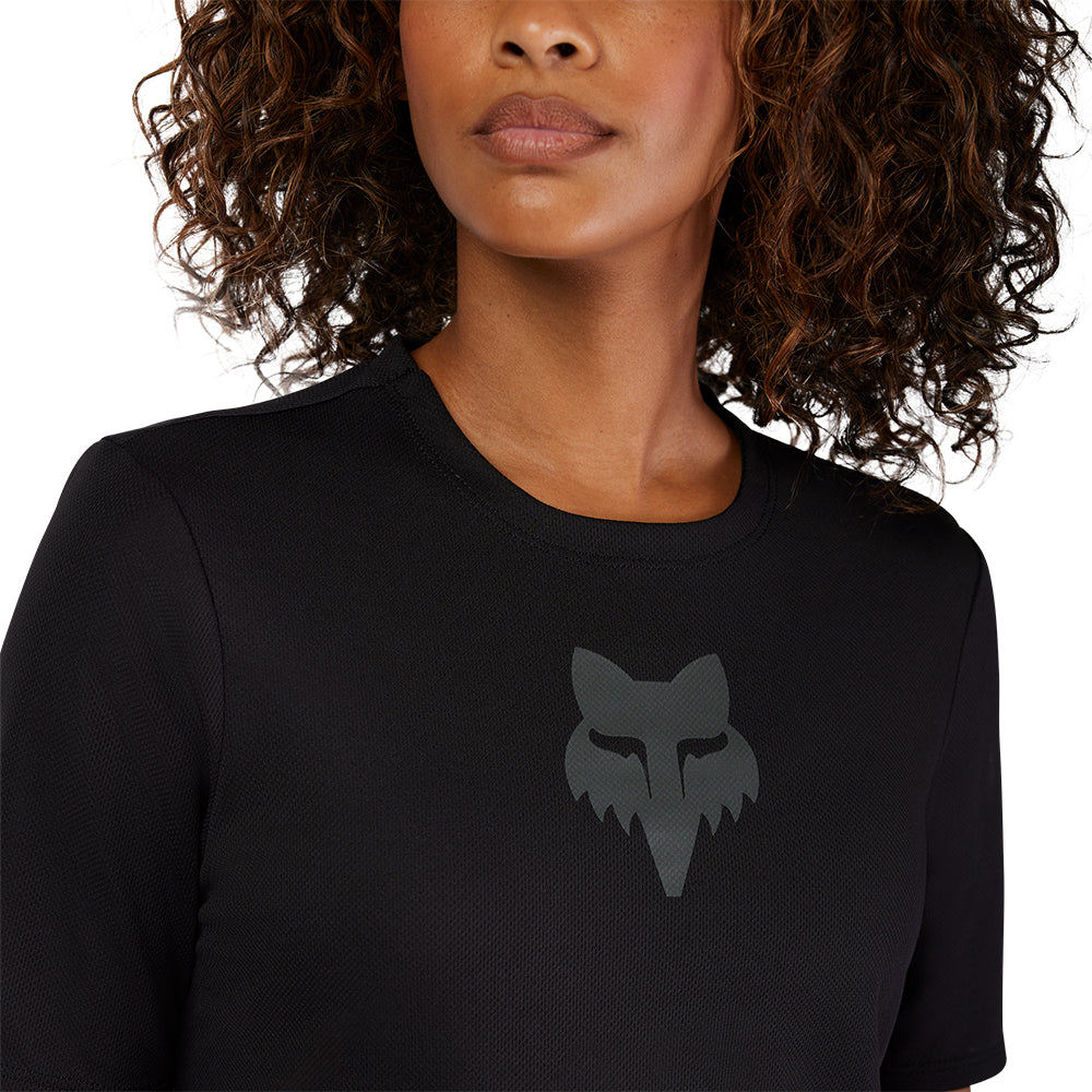 Black long-sleeve shirt with a wolf head logo worn by a person