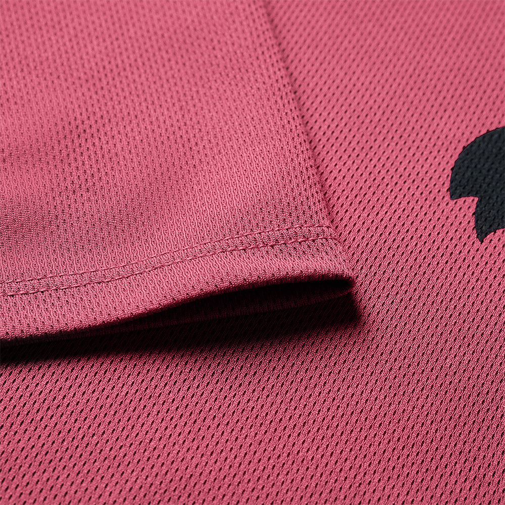 Close-up of a pink textured fabric with a black logo on the right side.