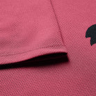Close-up of a pink textured fabric with a black logo on the right side.