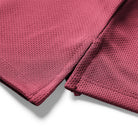 Close-up of a maroon fabric with textured pattern on a white background