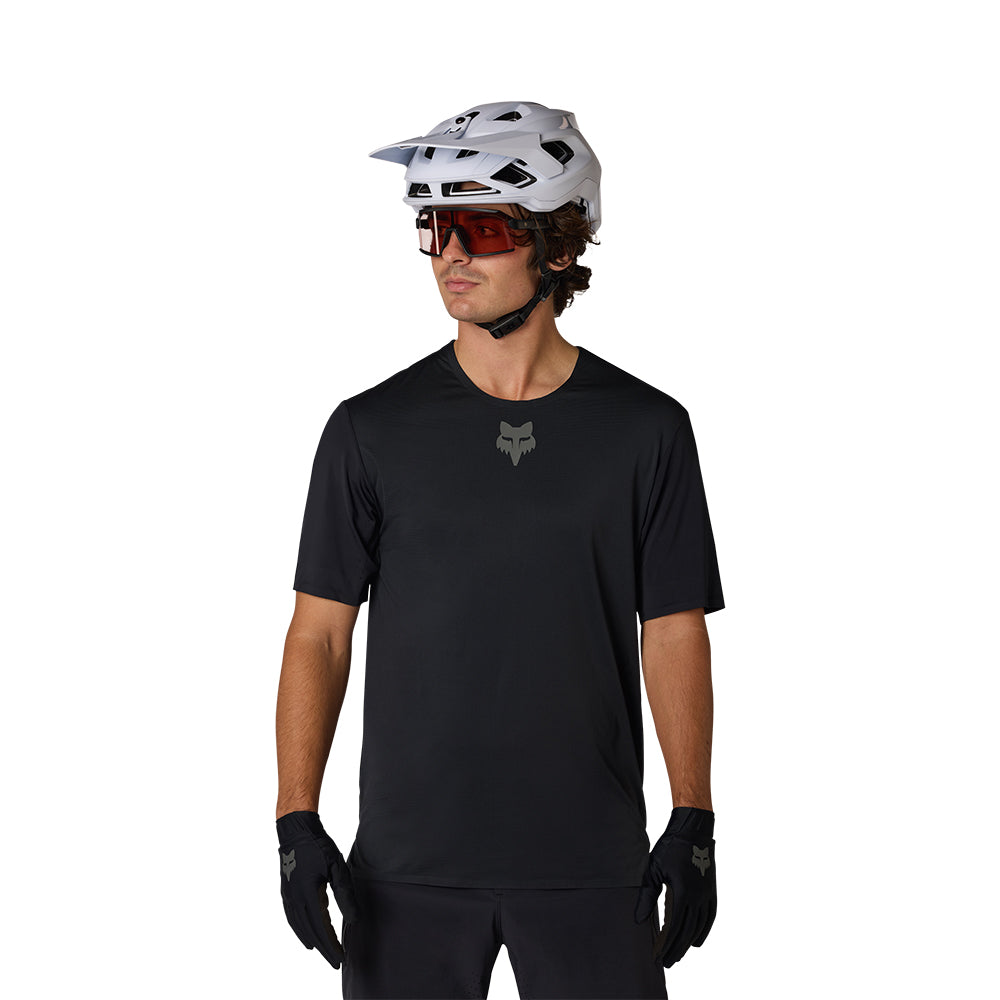 Person wearing a black t-shirt with a logo, white helmet, and sunglasses on a white background
