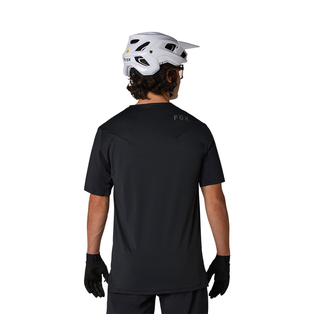 Person wearing a black t-shirt with 'FOX' branding, white helmet, and black gloves on a white background