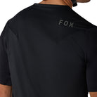 Black t-shirt with 'FOX' logo on the back, worn by a person.