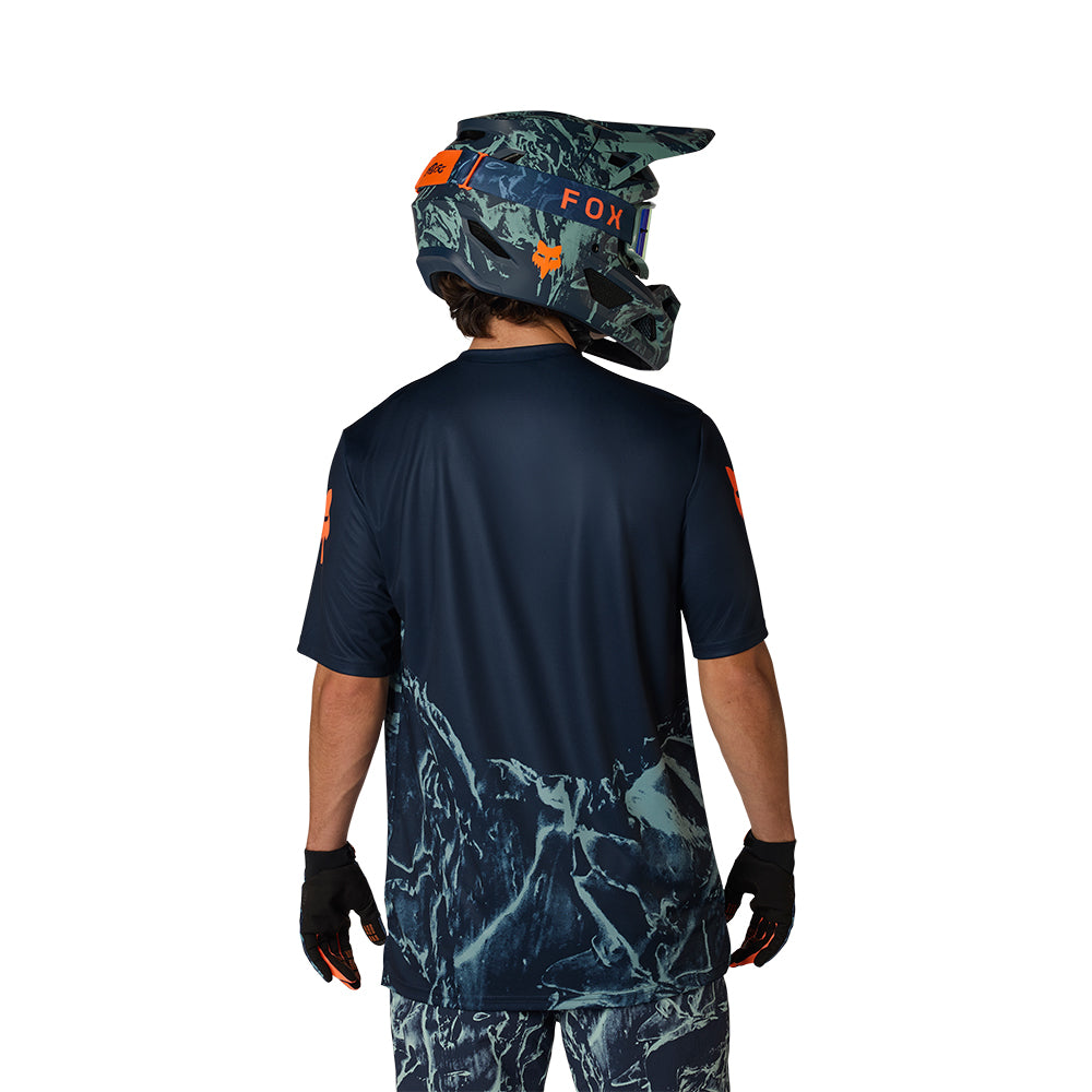 Person wearing a dark blue jersey, camouflage helmet, and gloves on a white background