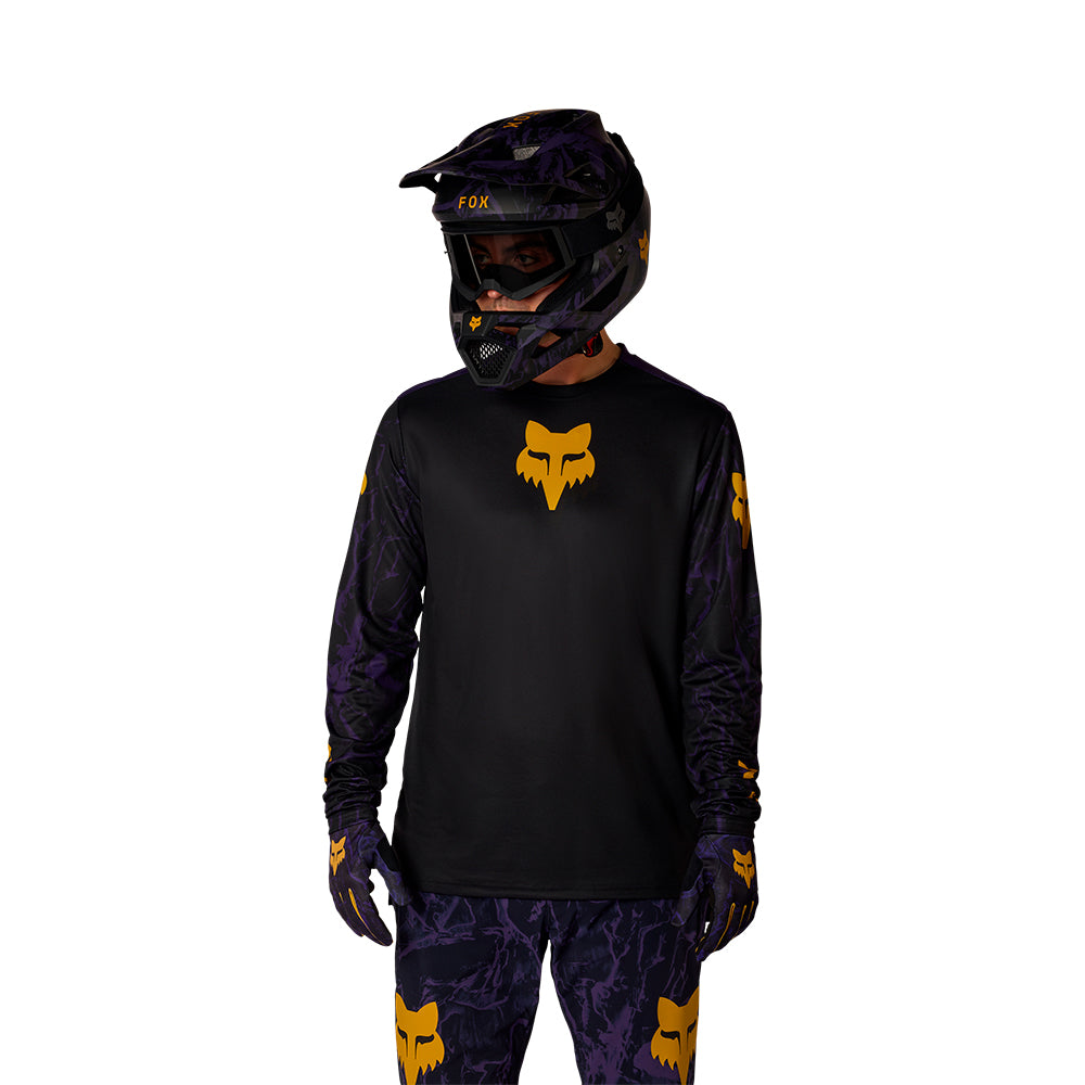 Person wearing a black and yellow motocross outfit with helmet on a white background