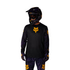 Person wearing a black and yellow motocross outfit with helmet on a white background