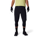 Person wearing black cycling shorts, gloves, and knee pads on a white background