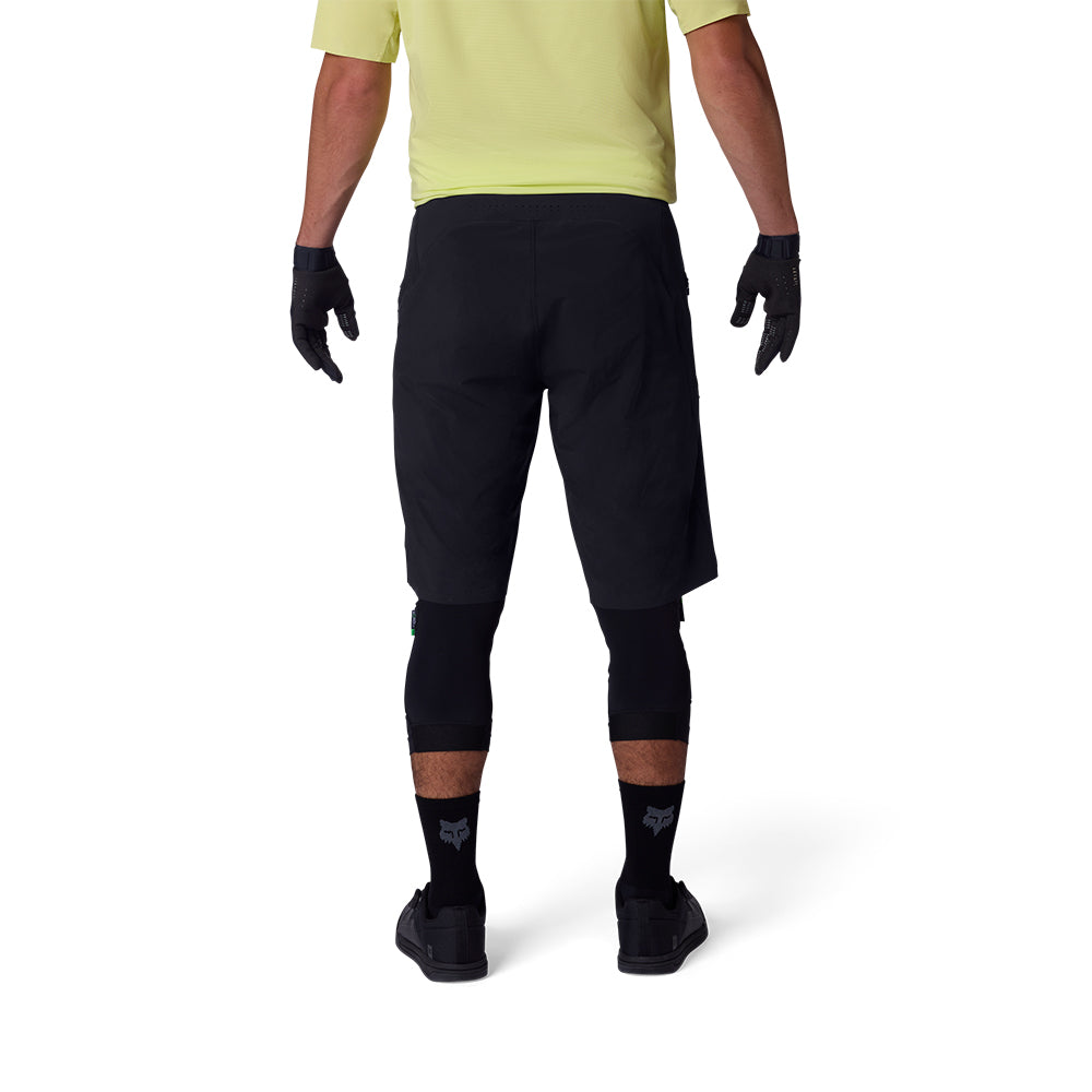 Person wearing black shorts, gloves, and socks on a white background