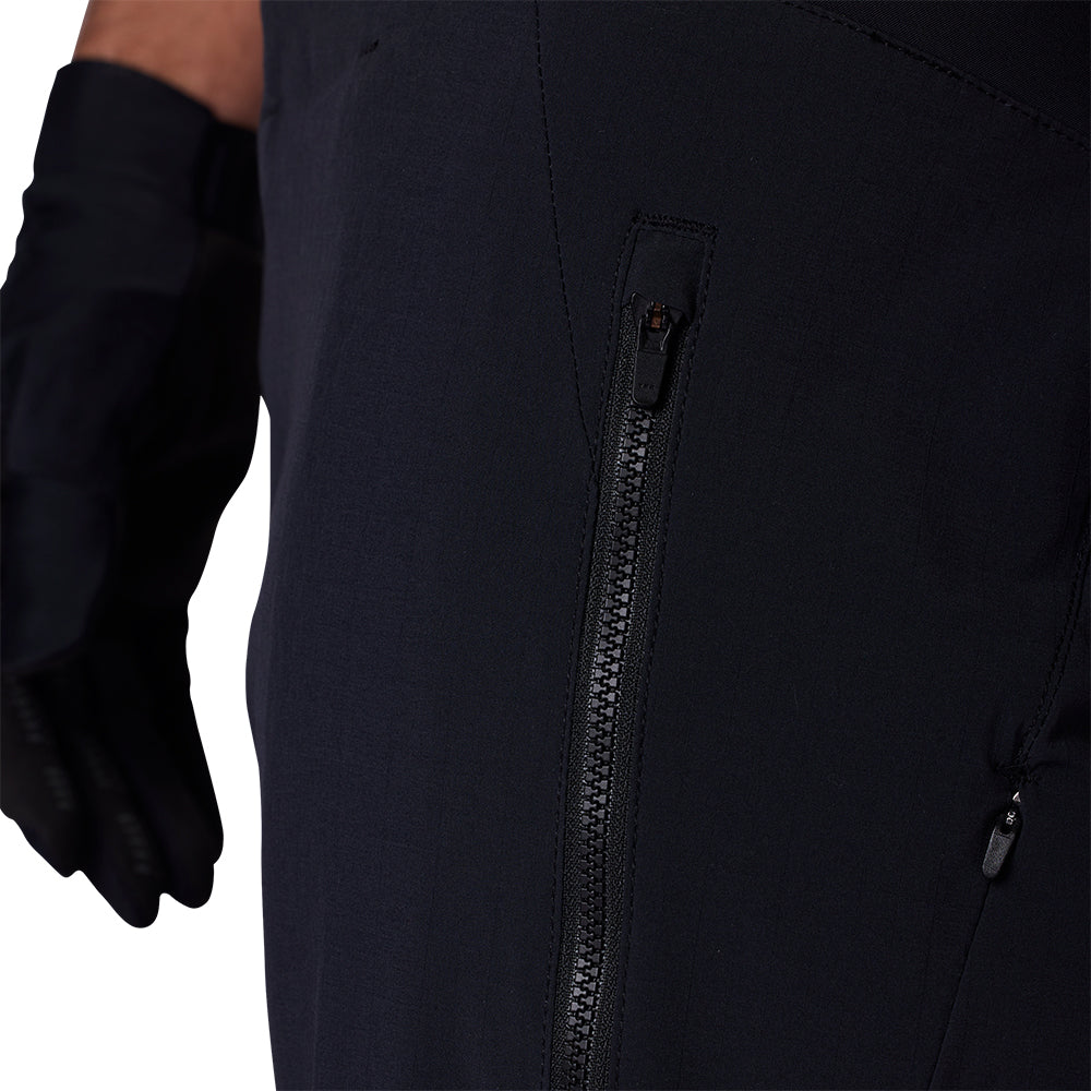 Close-up of a black jacket with a zipper and a gloved hand on a white background