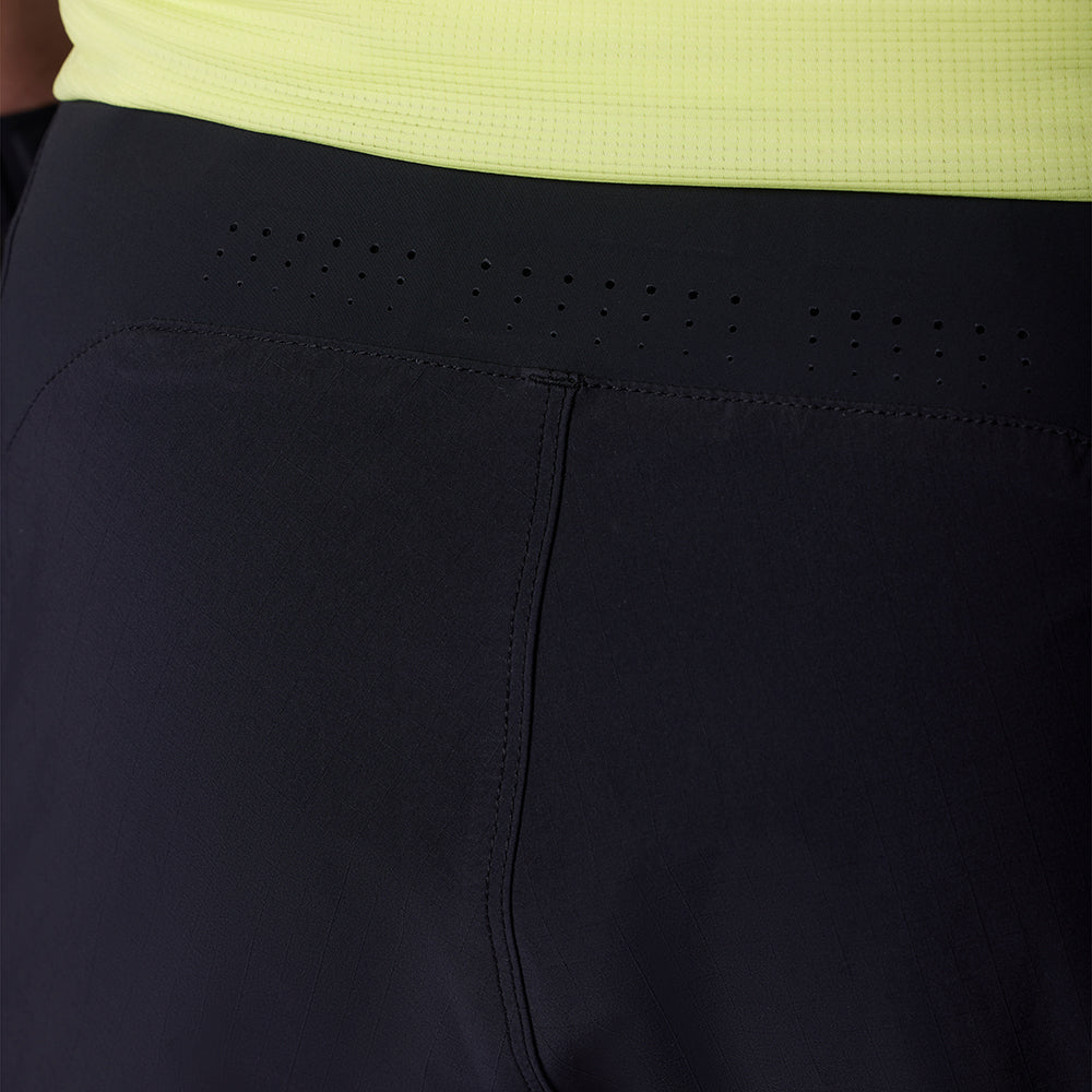 Close-up of black shorts with a yellow top, focusing on the waistband and stitching.