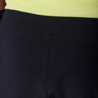 Close-up of black shorts with a yellow top, focusing on the waistband and stitching.