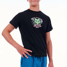 Person wearing a black t-shirt with a logo and blue shorts on a white background