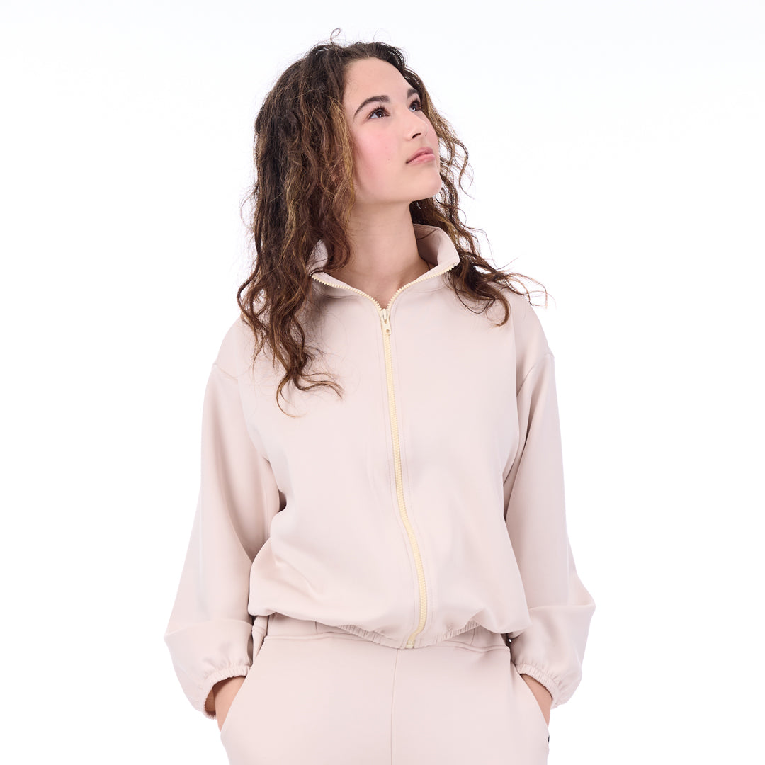 Woman wearing a beige tracksuit on a white background