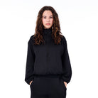 Person wearing a black tracksuit on a white background