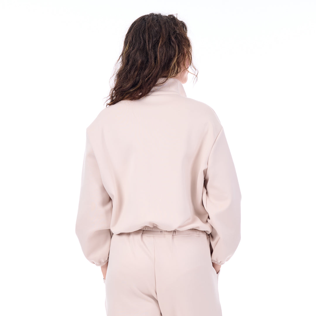 Person wearing a light pink outfit on a white background
