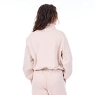 Person wearing a light pink outfit on a white background