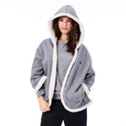 Woman wearing a gray hoodie with white trim on a white background
