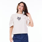 Woman wearing a white blouse with a black floral design on a white background