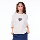 Woman wearing a white shirt with a black design on a white background