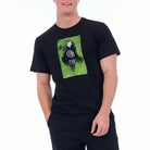 Person wearing a black t-shirt with a green graphic design on a white background