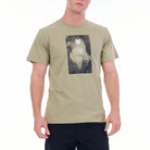 Man wearing a beige t-shirt with a graphic design on a white background
