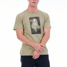 Person wearing a green t-shirt with a graphic design on a white background