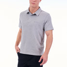 Person wearing a gray polo shirt with a brand logo on a white background