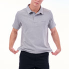 Person wearing a gray polo shirt with a brand logo on a white background
