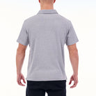 Person wearing a gray polo shirt on a white background