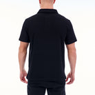 Person wearing a black polo shirt on a white background