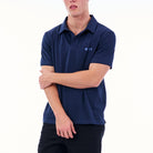 Person wearing a navy blue polo shirt with a logo on a white background