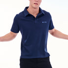 Person wearing a navy blue polo shirt with a brand logo on a white background