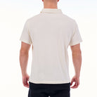 Person wearing a white polo shirt on a white background