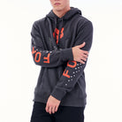 Person wearing a dark gray hoodie with orange text on sleeves against a white background